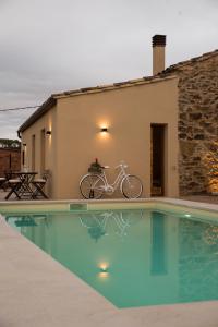 ein Fahrrad neben einem Haus mit Pool geparkt in der Unterkunft Mas Fidel Turisme in Llambillas
