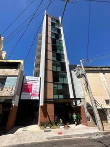 a tall building with people standing outside of it at Studio Novo com ar ao lado da Igreja São Mateus in Juiz de Fora