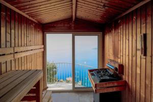 a room with a stove and a balcony with a window at La Chèvre d'Or in Éze