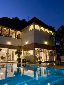a large house with a swimming pool at night at Unique 3BR Villa with Pool 5 minute walk to the Pererenan beach in Canggu