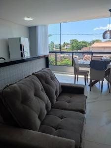 ein Wohnzimmer mit einem braunen Sofa und einem Tisch in der Unterkunft Apartamento Brisa da Ilha in Cayru