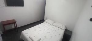 a small room with a white couch and a table at Pousada Elefantinho in São Pedro da Aldeia