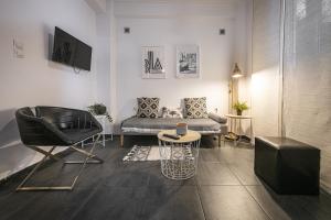 ein Wohnzimmer mit einem Sofa und einem Stuhl in der Unterkunft Charming Studio next to Kallimarmaro Stadium in Athen