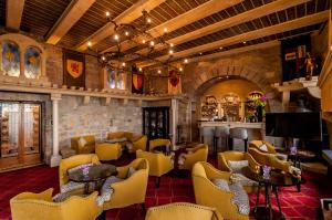 a bar with yellow chairs and tables and a room with a bar at La Chèvre d'Or in Éze