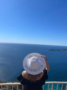 a woman wearing a hat with the words happy wednesday at La Chèvre d'Or in Éze