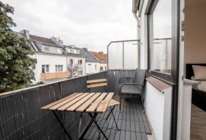 a wooden bench on a balcony with a table at Moderne 2-Zimmer Wohnung Bremen in Bremen