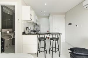 a kitchen with two bar stools in a room at Modern Studio Apartment In Los Laureles in Asunción