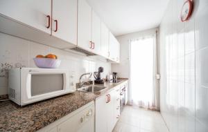 a white kitchen with a sink and a microwave at Stunning apartment in Oropesa del Mar in Oropesa del Mar