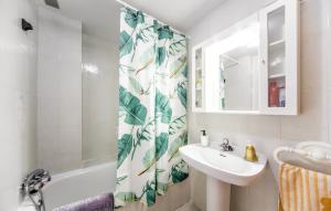 a bathroom with a sink and a shower curtain at Stunning apartment in Oropesa del Mar in Oropesa del Mar +6 photos