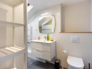 La salle de bains blanche est pourvue d'un lavabo et d'un miroir. dans l'établissement La suite Palais Ducal, à Nancy