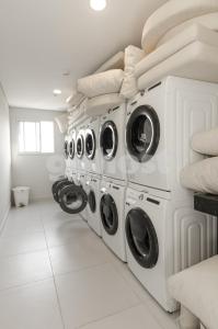 a laundry room with a row of washers and dryers at Modern Studio Apartment In Los Laureles in Asunción