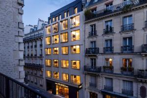 a tall building with lit windows in a city at Hôtel Pilgrim in Paris