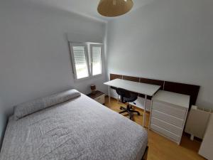 1 dormitorio con cama, escritorio y escritorio en Apartamento parque las llamas, en Santander