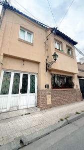 a house with white doors and windows on a street at Hermoso apartamento centrico! in Salta +26 photos