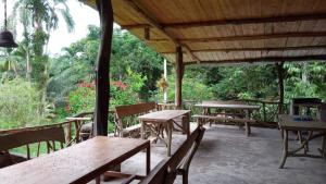 a group of wooden tables and benches under a pavilion at Itapoa Reserve in Puerto Quito