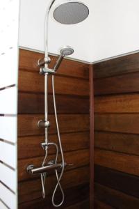 y baño con ducha y pared de madera. en Villa Piscine - Bougainvillier, en Les Anses-dʼArlet
