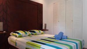 1 dormitorio con cama con cabecero de madera y almohadas en Villa Piscine - Bougainvillier, en Les Anses-dʼArlet
