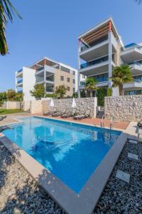 a swimming pool in front of a building at VIPo Prestige Apartments in Podstrana