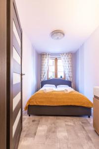 a bedroom with a bed and a window at RentPlanet - Apartamenty Leśny Dom in Karpacz