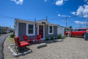 una casa con dos sillas y una mesa delante. en 217 Old Wharf Road 1A Dennis Port Cape Cod Grey Pearl, en Dennis Port