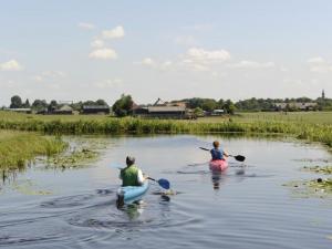 dwoje ludzi jest w kajakach w rzece w obiekcie Camping De Hof van Eeden w mieście Warmond