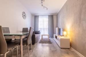 a living room with a dining table and a living room with a television at RentPlanet - Apartamenty Leśny Dom in Karpacz