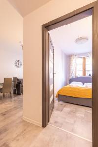 a bedroom with a bed and a sliding door at RentPlanet - Apartamenty Leśny Dom in Karpacz