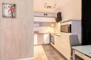 a kitchen with white cabinets and a table at RentPlanet - Apartamenty Leśny Dom in Karpacz