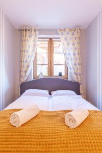 a bedroom with a bed with two towels on it at RentPlanet - Apartamenty Leśny Dom in Karpacz