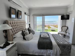 sypialnia z dużym łóżkiem i widokiem na ocean w obiekcie Shelley Point On Sea w mieście St Helena Bay