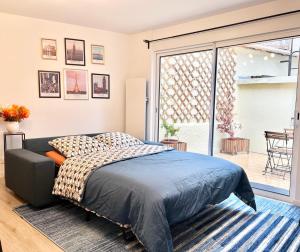 a bedroom with a bed and a sliding glass door at House climatisée & parking à 15 minutes de Paris in Bagneux