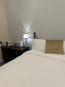 a bedroom with a white bed and a desk with a lamp at Windsor Wine and Dine in Chertsey