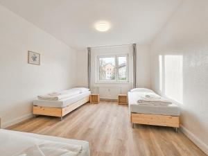 a room with two beds and a window at Tolstov Apartments - Monteurwohnungen - 2 Schlafzimmer - Küche - Balkon - Waschmaschine in Heiligenhaus