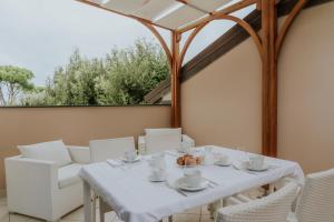 a white table and chairs on a patio with a window at Il Delfinetto in San Vincenzo