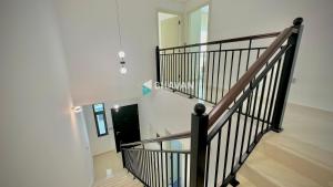 a staircase in a house with a black railing at Calm Chaos 4 BR Villa with maid Room in Damac Hills 2 in Dubai