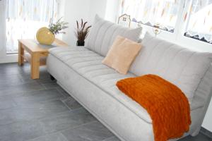 a gray couch with an orange blanket on it in a living room at Sellraintaler Auszeit 2 in Sellrain