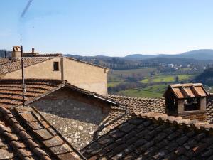 vista sui tetti delle case con montagne sullo sfondo di Scappo in Umbria, la Loggia ad Amelia