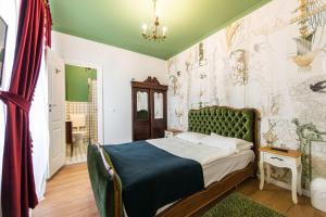 a bedroom with a bed with a green headboard at Casa Antiqua in Braşov