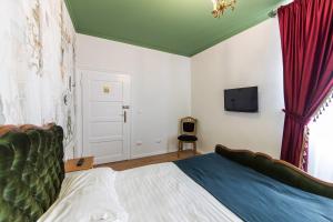 a bedroom with a bed and a tv on the wall at Casa Antiqua in Braşov