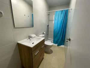baño con lavabo y aseo con cortina de ducha azul en Complejo Bubal Formigal 3000, en Búbal