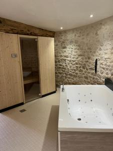 a bathroom with a bath tub in a room at Ferme de Mesangeon in Beauvilliers +42 photos