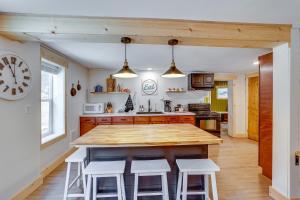 a kitchen with a large wooden table and white stools at Avery Creek Cabins Hike, Bike, Fish and More! 