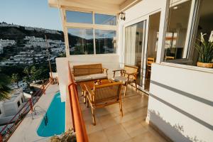 een terras met een tafel en stoelen op een balkon bij El Libre - Ocean View Apartment in Puerto Rico de Gran Canaria