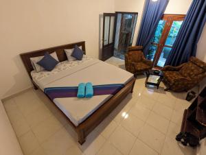 een slaapkamer met een bed met een blauwe boog erop bij Ceyio traditional villa in Matara