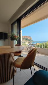 a room with a table and chairs and a large window at L'Ipanema - Standing T2 + Balcon in Cassis