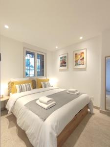 a white bedroom with a large bed with towels on it at L'Ipanema - Standing T2 + Balcon in Cassis