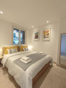 1 dormitorio con 1 cama grande y toallas. en L'Ipanema - Standing T2 + Balcon, en Cassis