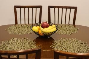 a bowl of fruit on a table with two chairs at Golden Velvet apartment Belgrade in Belgrade