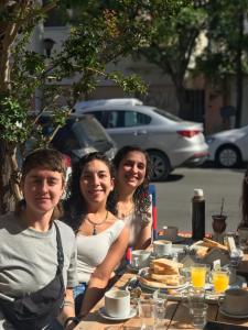 een groep mensen die aan een tafel zitten bij Il Point Hostel Cafe in Neuquén