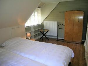 a bedroom with a white bed and a wooden floor at Chalet de Vasterival in Varengeville-sur-Mer